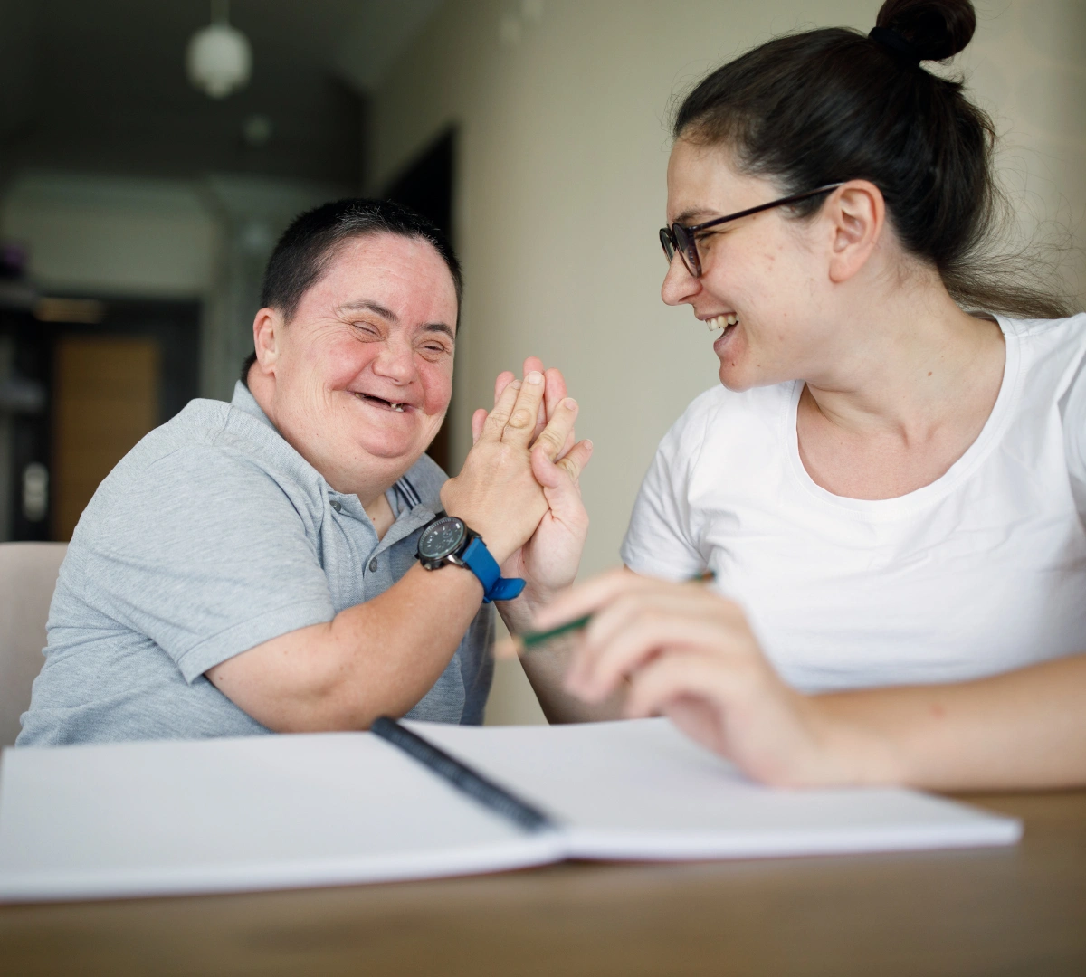 Support worker high fiving disabled woman