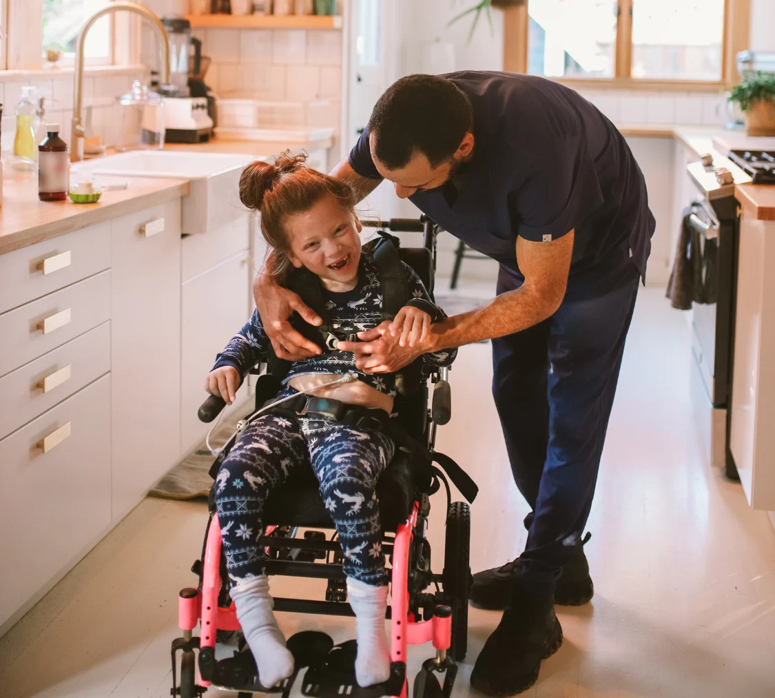Disabled girl at home in wheelchair with support worker