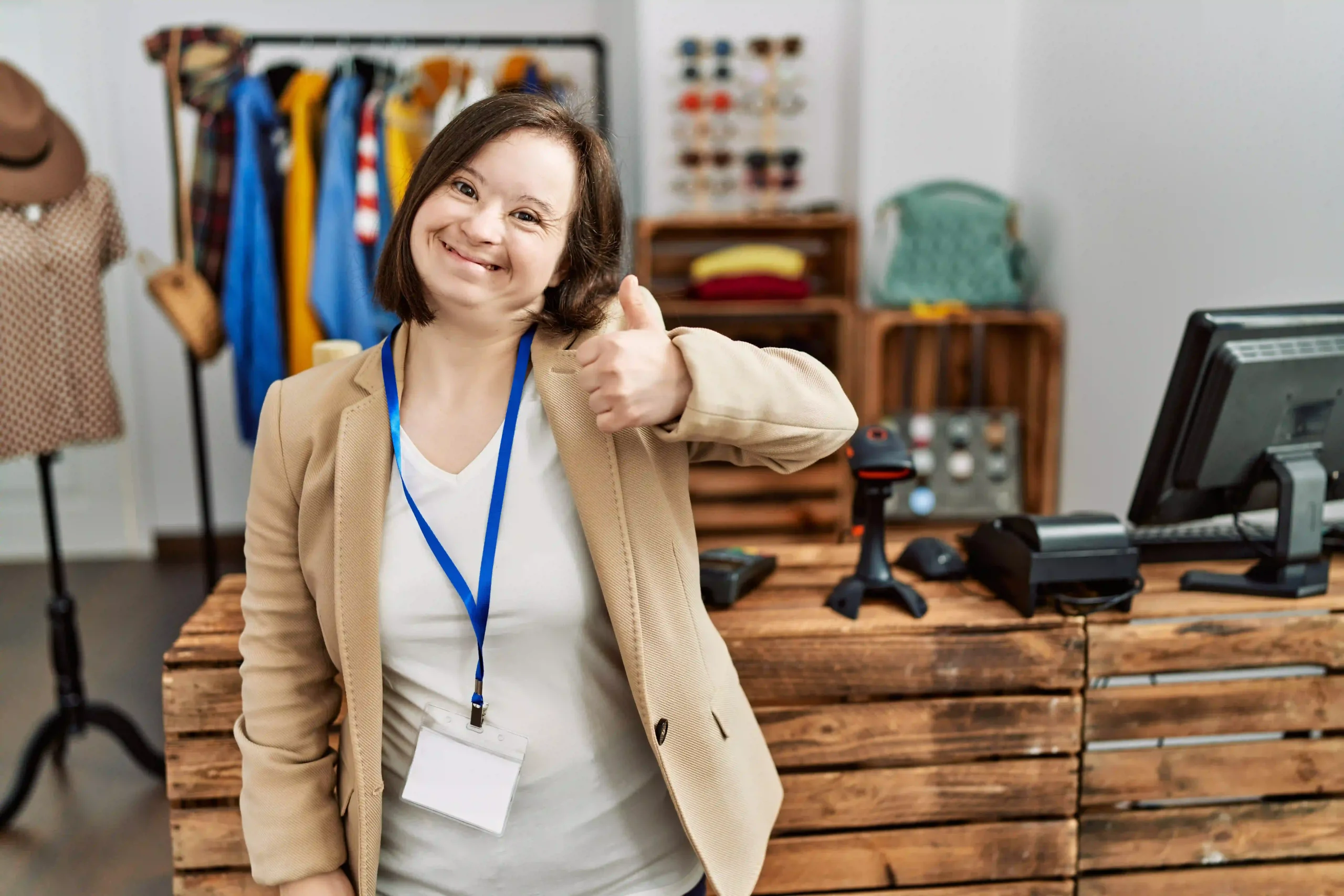 Disabled girl with down syndrome at work smiling and giving thumbs up to camera